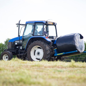 Tractor handling a bale